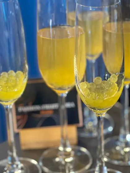 A playful and modern drink featuring passion fruit boba pearls. These pearls add a fun texture and a burst of tropical flavor to the sparkling beverage.