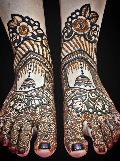 Bridal feet deserve just as much attention. This design features beautiful jhumka (bell) motifs, surrounded by delicate netting and floral patterns, creating an elegant look for the bride's feet.