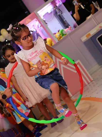 Fun and games. A young guest enjoys a hula hoop game during a party.