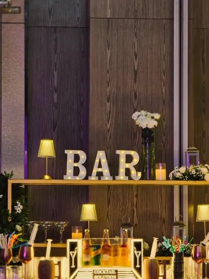 The full bar setup, complete with a 'BAR' marquee sign. We design functional spaces like bars to be fully integrated into the event's overall aesthetic.