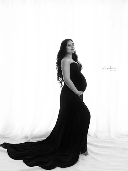 There is a timeless elegance in monochrome. This black and white studio portrait focuses purely on form, light, and emotion. The simple, classic composition highlights the beautiful curve of the baby bump, creating a powerful and intimate fine art maternity portrait.