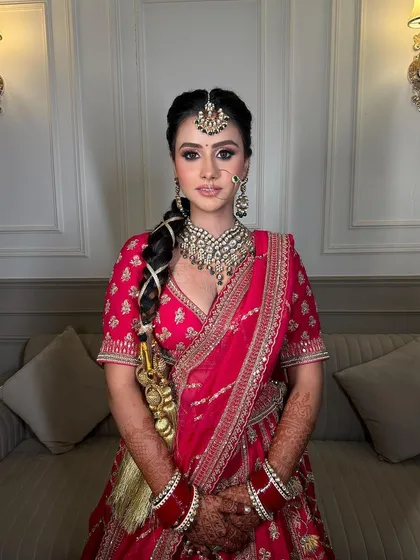 A classic pose showing the intricate details of the bridal jewellery, from the choker to the maang tikka and nath.