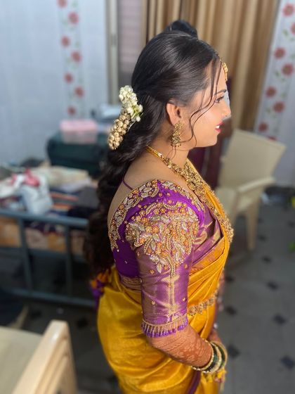 A beautiful bridal hairstyle featuring a side-swept look with curls and fresh flowers.