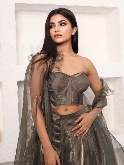 A chic and modern bridesmaid look in a metallic grey-brown organza. The outfit features a structured corset top and a flowing skirt with a matching ruffled dupatta.