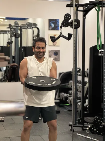 A client holds a weight plate, getting ready for his next set. The gym is equipped with everything needed for a comprehensive strength program.