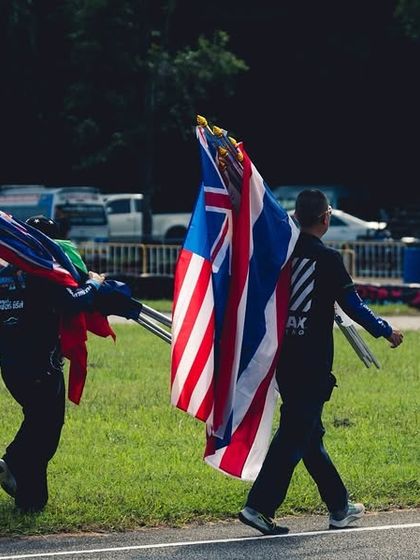 Officials carry the flags of participating nations at the end of the RMC Asia Max race.