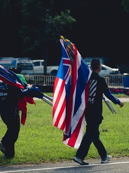 Officials carry the flags of participating nations at the end of the RMC Asia Max race.