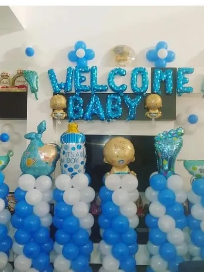 A 'Welcome Baby' decoration with blue and white balloon columns and various baby-themed foil balloons.