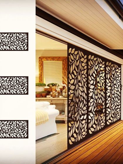 Laser-cut screens are a beautiful way to partition a space without closing it off completely. This intricate leaf-patterned screen acts as a sliding door, separating the living area from the outdoor deck while allowing light to pass through.