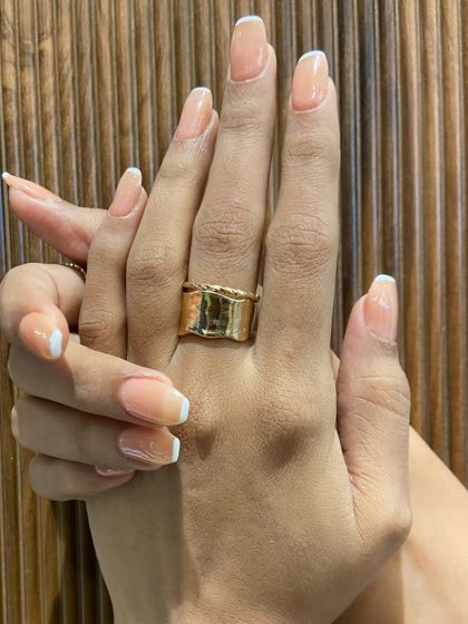 A close-up of the finished look against a textured background. Notice the clean lines and the healthy, glossy shine of the gel extensions.