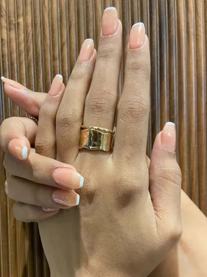 A close-up of the finished look against a textured background. Notice the clean lines and the healthy, glossy shine of the gel extensions.