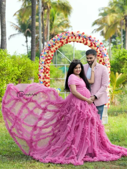 A fairytale moment with a flowing pink ruffled gown and a floral arch. The flying fabric adds a touch of magic to this couple's portrait.