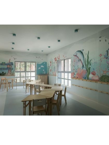 This view of the aqua classroom highlights the different zones for learning. The combination of open floor space and grouped tables allows for a variety of activities throughout the day.