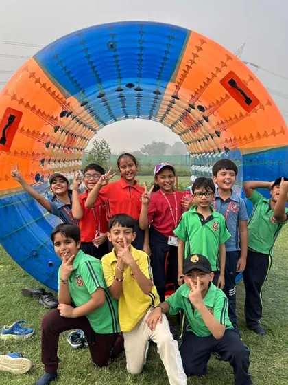 A group of friends poses with a zorbing roller at the adventure camp. We offer a wide range of thrilling activities to keep the students engaged and entertained throughout the day.