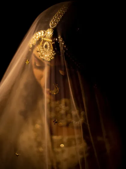 An ethereal bridal portrait, with the bride's face softly lit through her veil. This shot is all about grace and elegance.