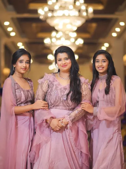 A beautiful photo of a mother with her daughters at Purvi's 5th birthday party, all dressed in matching lavender outfits.