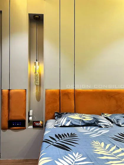 A close-up of the bedside detail in this master bedroom. The hanging pendant light provides focused light for reading, while the niche in the headboard is a convenient spot for a phone and alarm clock.