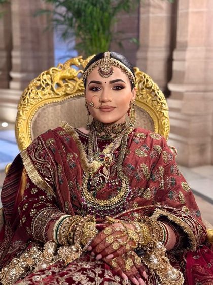 A queen on her throne. This portrait captures the serene and powerful presence of the bride, with makeup that enhances her features with grace.