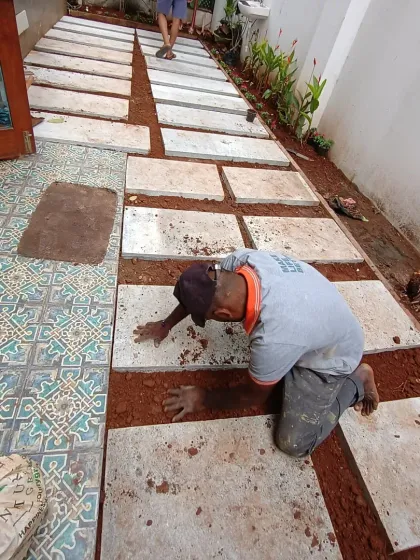 The installation of the stepping stones is nearly complete. I ensure precise spacing to allow for grass to grow between them, creating a classic garden look.
