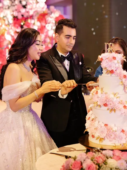 The perfect moment. We love seeing our clients enjoy the centerpiece we created for them. This photo captures the joy of the cake-cutting ceremony with our romantic floral spiral wedding cake.