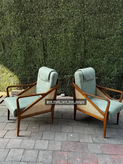 Side view of the pair of sage green lounge chairs.