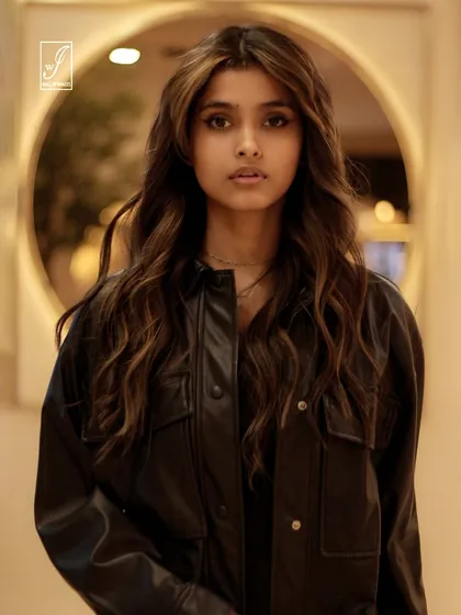 A direct and engaging portrait, framed by a circular light element in the background, which adds depth and visual interest.