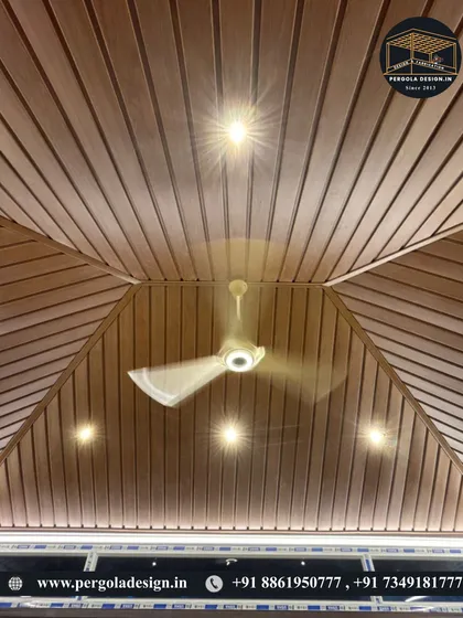 The beauty is in the details. This upward view showcases the flawless finish of a wood-paneled PVC ceiling, complete with recessed lighting and a fan, ensuring comfort and elegance within the glass enclosure.