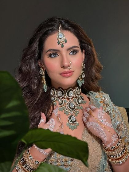 A close-up of the bride's face, her makeup catching the light beautifully. This look is for the bride who carries her legacy with grace.