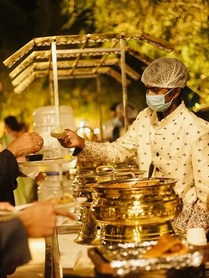 My service staff, in uniform and following all hygiene protocols, serving guests at a wedding buffet. I ensure my team is professional, friendly, and efficient.