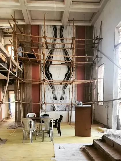 On-site progress at the Afsar Sheikh residence, showing the installation of the towering book-matched marble wall. This image captures the scale of the project and the precision required during the construction phase.