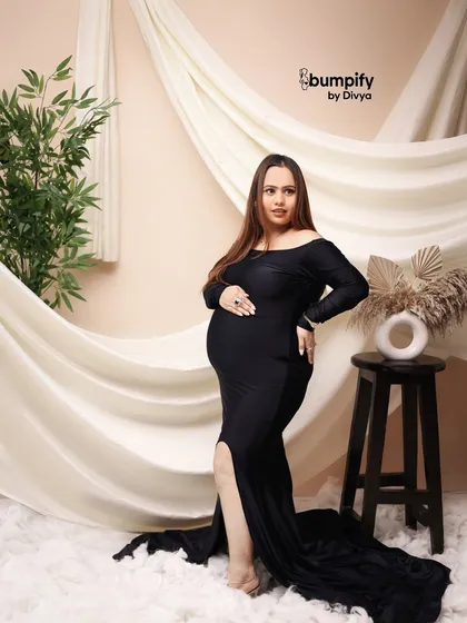 A simple yet stunning portrait in a classic black gown. The soft, white draped background and the single plant prop create a minimalist and modern feel.