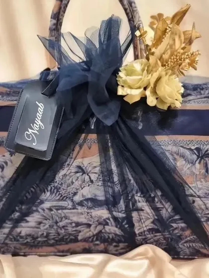 A beautifully wrapped tote bag from the anniversary gift set, personalised with a custom luggage tag for 'Nayaab'.