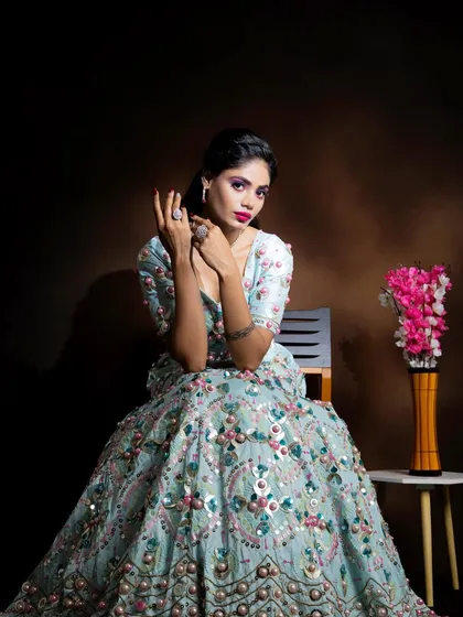 A full-length seated portrait, showing how the makeup and outfit come together for a stunning, modern ethnic look.