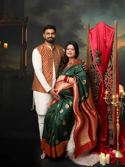This gorgeous mommy opted for traditional wear, and the result is stunning. The green and red saree, paired with her partner's printed jacket, creates a rich and vibrant couple portrait.