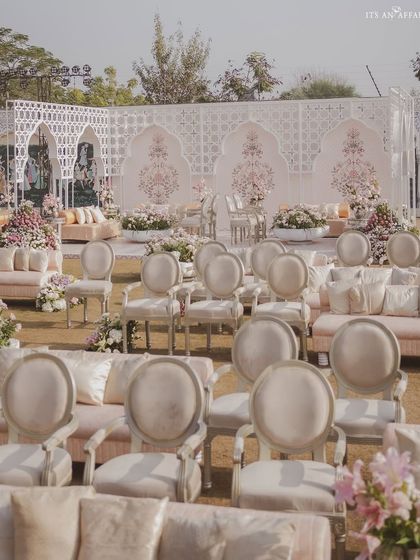 A wide view of the guest seating arrangement, combining elegant chairs and plush sofas in pastel hues. The layout is designed to feel open and luxurious, facing the grand stage.