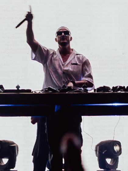 DJ Snake, microphone in hand, ready to hype up the massive crowd.