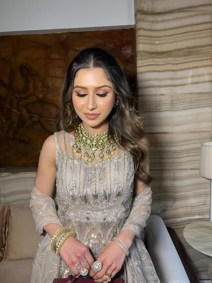 Eyes closed, this shot focuses on the warm, bronzy eye makeup and the dewy finish of the skin.