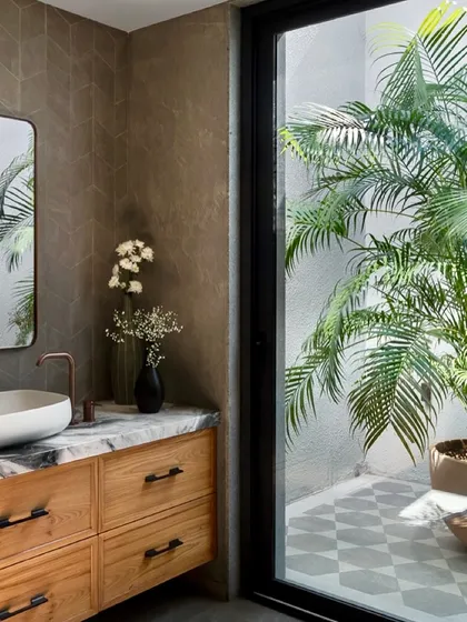 This bathroom in the Mango Orchard House opens up to a private, open-to-sky courtyard filled with plants. This connection to nature brings an abundance of natural light and a sense of tranquility to the space.