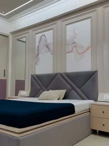 A bedroom design featuring a geometric grey headboard and modern art panels. The mix of grey and lilac tones creates a unique and personalized color scheme.
