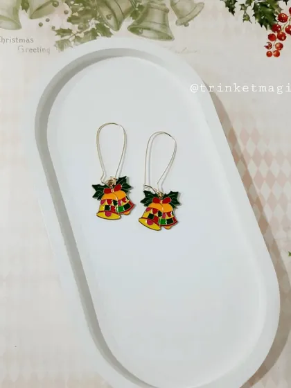 Jingle all the way with these Christmas bell hoop earrings. The colorful enamel bells will add a cheerful sound and look to your holiday outfit.
