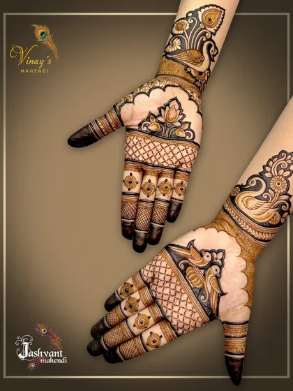 A pair of hands showing a mirrored peacock design. This is a lovely option for friends or sisters getting their mehndi done together.