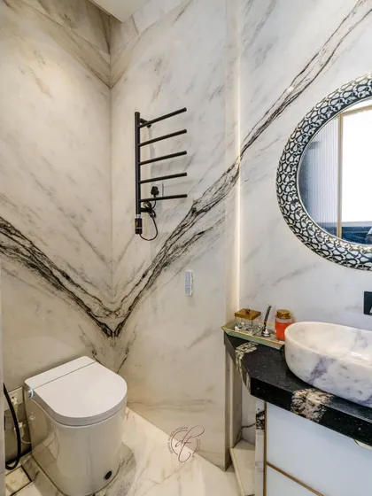 This view showcases the striking veining of the marble walls, which creates a powerful visual statement. The minimalist design of the smart toilet and fixtures allows the natural beauty of the stone to shine.