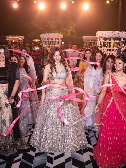 Your tribe should always match your vibe. This is a beautiful shot of the bride entering with her bridesmaids, using pink ribbons to create a unique and connected entry moment.