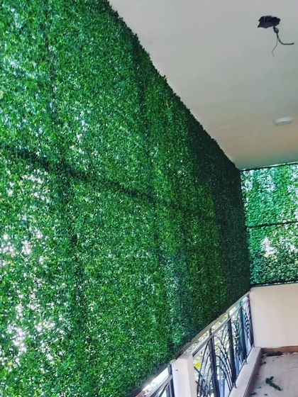 A massive green wall installation covering the entire side of a multi-level balcony. This is an effective way to add greenery and privacy to large residential buildings.