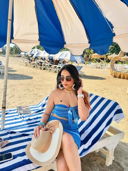 A relaxed pose on the beach. The blue and white stripes of the towel and umbrella perfectly match my outfit.