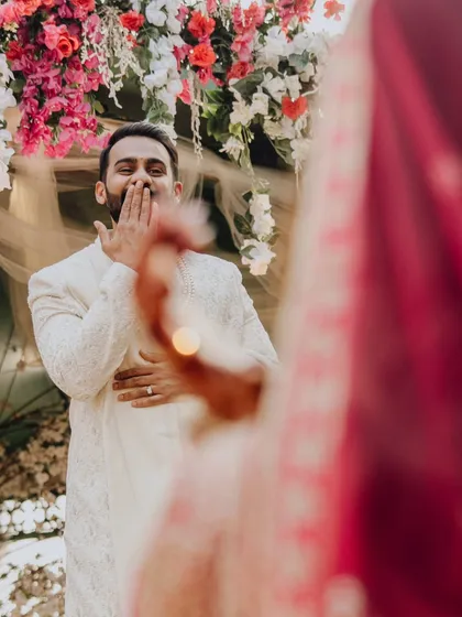 The groom's reaction to his bride's playful gesture during the Varmala. A candid moment of love and laughter.