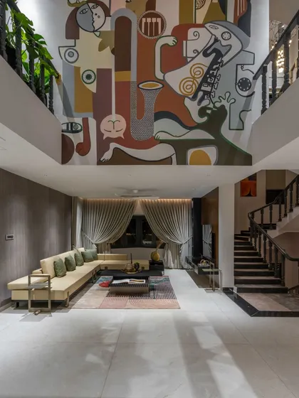 A double-height wall is not a challenge; it's a grand canvas waiting for its story. In this 'House of the Rising Sun' project, we created a massive mural that becomes the architectural soul of the home, connecting two floors with a single, continuous narrative of abstract faces and musical forms under a sunlit skylight.