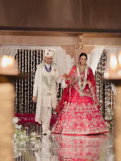 The couple walking hand in hand after their wedding ceremony, framed by the warm glow of candles.