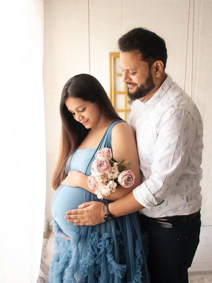 A quiet and tender moment during a pregnancy shoot. The focus on the baby bump and the couple's gentle interaction makes this photo so special.