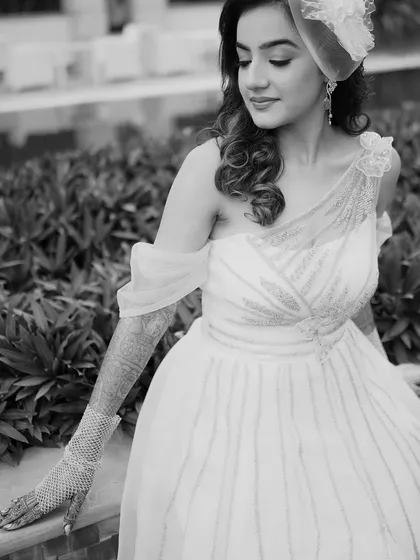 A classic black and white portrait of the bride. Her gentle expression and the soft light create a timeless and beautiful image, highlighting the details of her gown and henna.